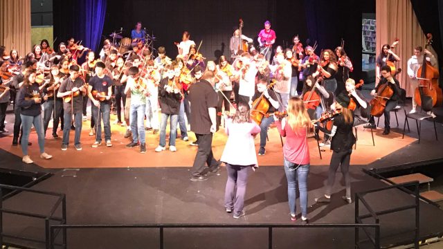Orchestra students rehearsing with Barrage 8 before the concert.