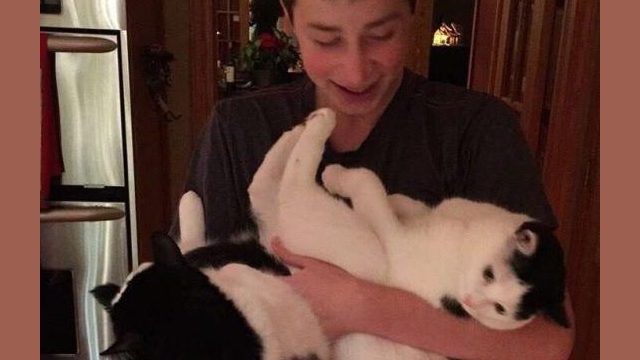 Graham holding his cats, Aela (left) and Lily (right).