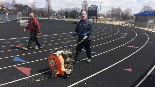 Equipment Manager Ken Gaughan prepares the track for a meet.