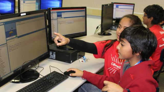 Nikita Basu, '19, teaches the logic behind giving a computer commands.