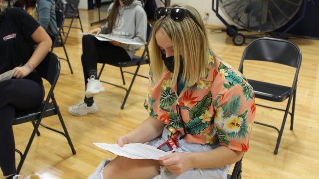 Sam Grazulis, '23, reads important consent information while waiting to donate.